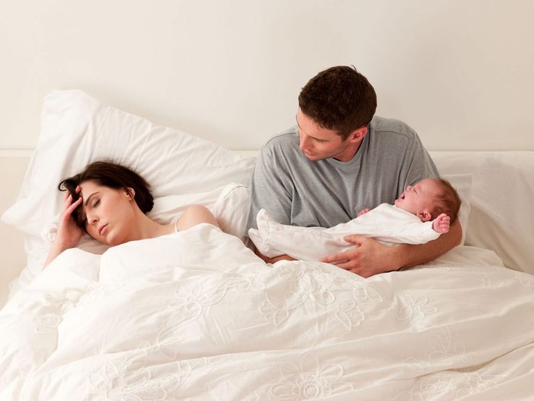 أب يحمل طفله حديث الولادة - أرشيفية