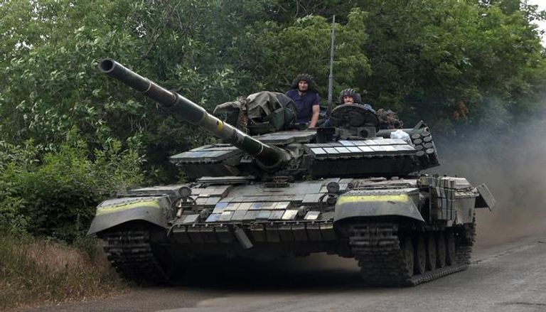 جنود أوكرانيون يركبون دبابة على طريق بمنطقة لوهانسك الشرقية