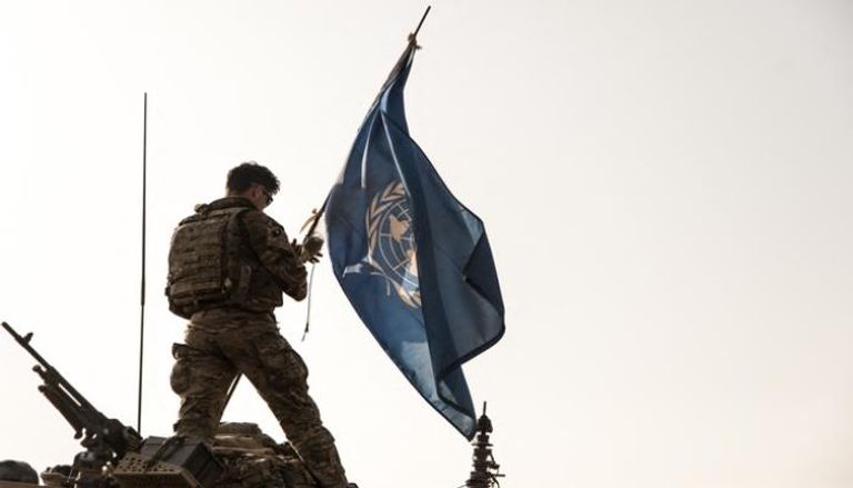 جندي من بعثة مينوسما يرفع علم الأمم المتحدة فوق مدرعة - أ ف ب