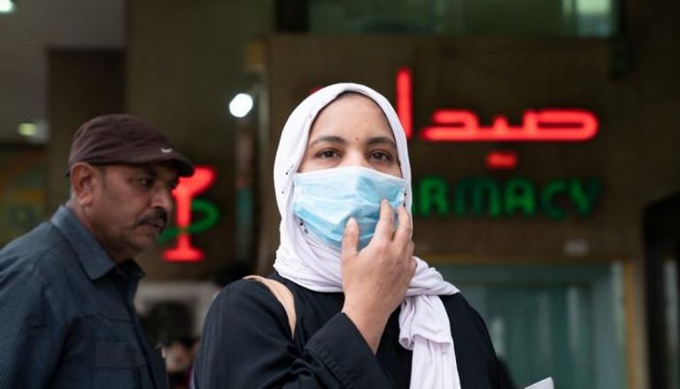 سيدة مصرية ترتدي الكمامة في الشارع