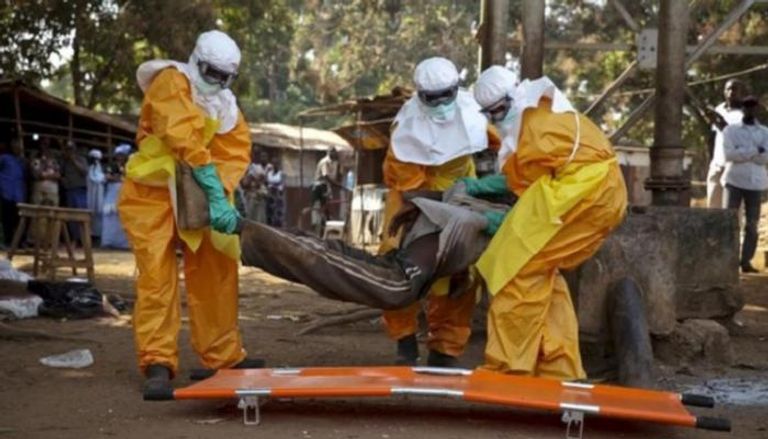 أعضاء الفرق الطبية تنقل شخصا قتله فيروس إيبولا