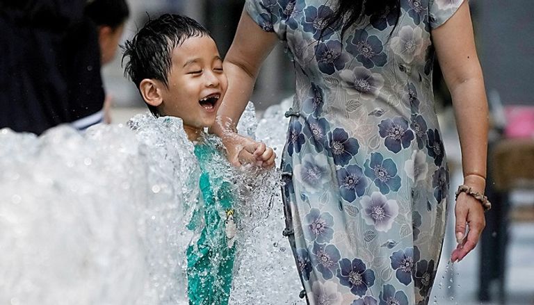 موجات الحر تضرب الصين طفلة صينية قرب نافورة مياه لمواجهة الحر - رويترز