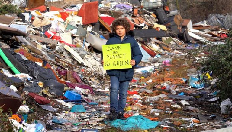 طفل يحمل لافتة تدعو لحماية الأرض