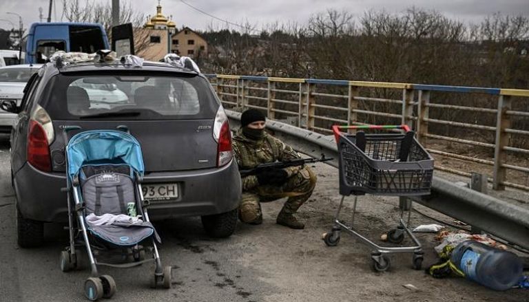 جندي أوكراني يختبئ خلف سيارة شمال غرب كييف - أ ف ب