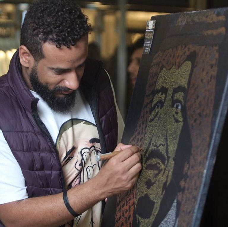 التشكيلي السعودي محمد باجبير مع لوحاته