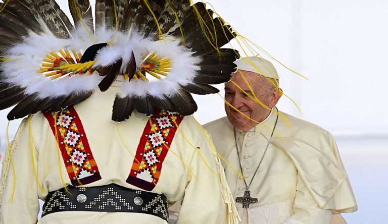 البابا فرنسيس مرتديا غطاء للرأس من الريش - الفرنسية