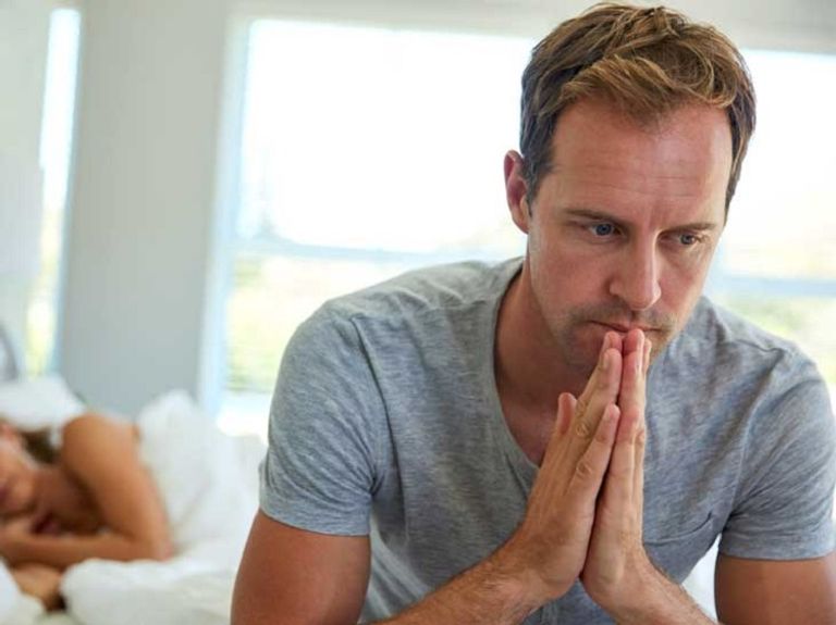 زوج وشريكته يجلسان على السرير - تعبيرية