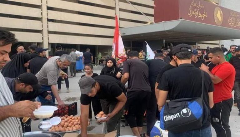 توزيع وجبات على المعتصمين أمام مقر البرلمان العراقي