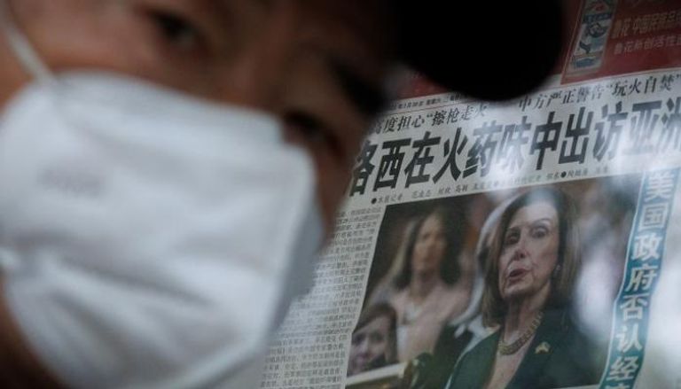 صيني أمام صحيفة معروضة تتناول زيارة بيلوسي المحتملة لتايوان
