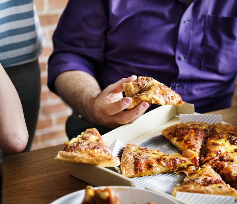 شخص يتناول المقرمشات وهو يعمل على الكمبيوتر