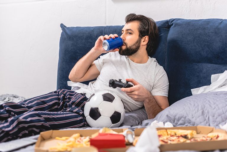 شخص يتناول المقرمشات وهو يعمل على الكمبيوتر