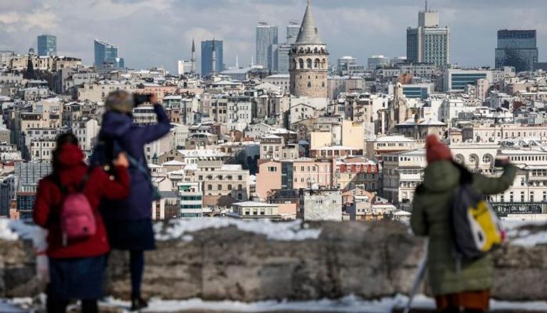 سياح أجانب يلتقطون صورًا تذكارية بإسطنبول