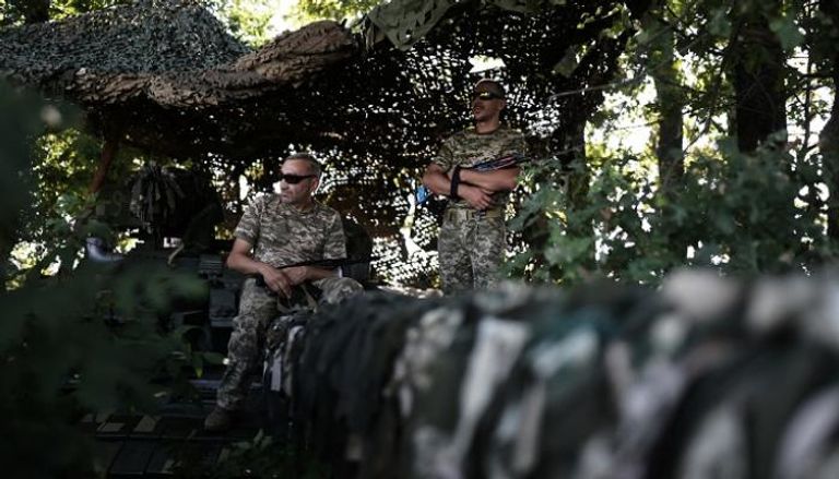 جنديان أوكرانيان يعتليان دبابة - رويترز
