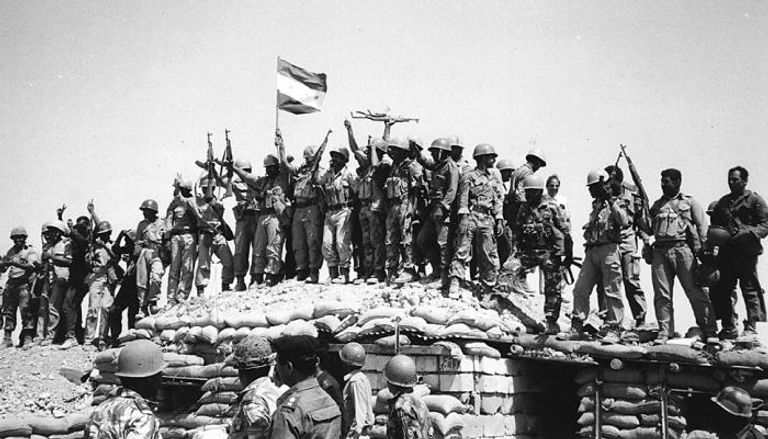 جنود عراقيون يرفعون راية النصر  في معركة خلال الحرب مع إيران