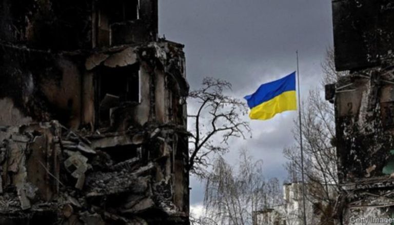 علم أوكراني بين أطلال المباني 