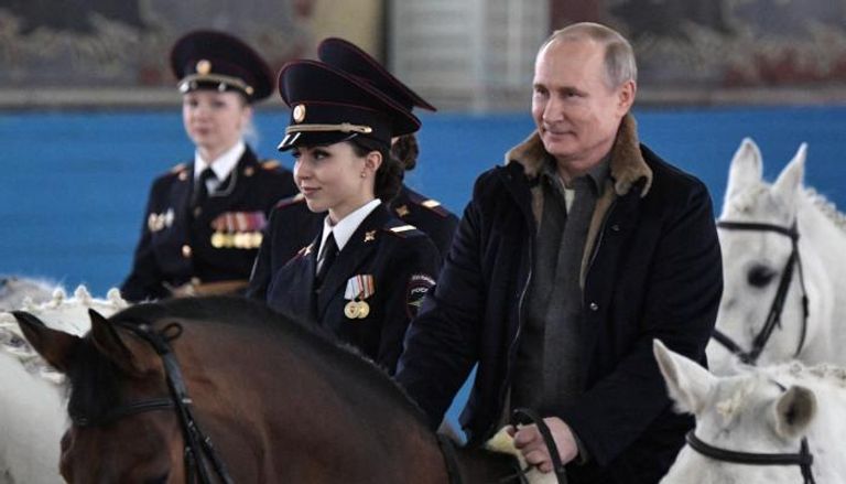 بوتين يمتطي حصانا برفقة ضابطات شرطة روسيات