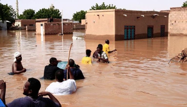 أشخاص تغمرهم مياه السيول في السودان