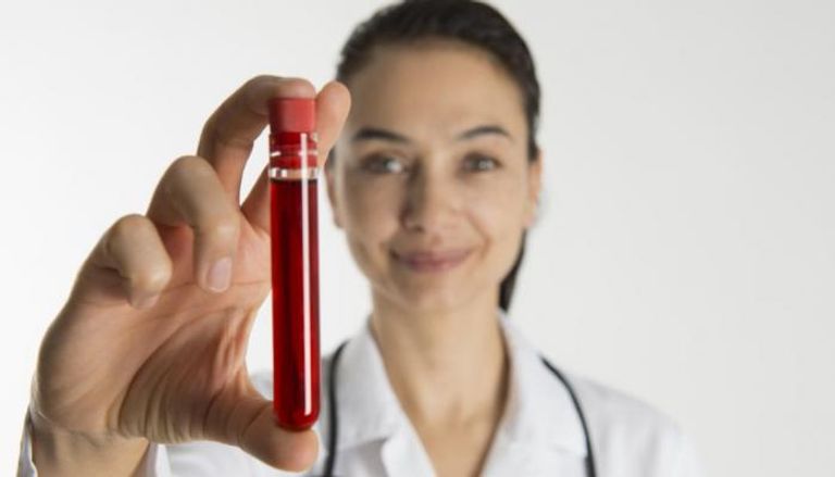 طبيبة تحمل اختبار دم لأحد المرضى - أرشيفية