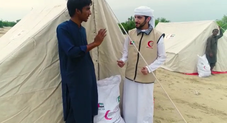 عناصر هيئة الهلال الأحمر الإماراتي مع متضرري الفيضانات