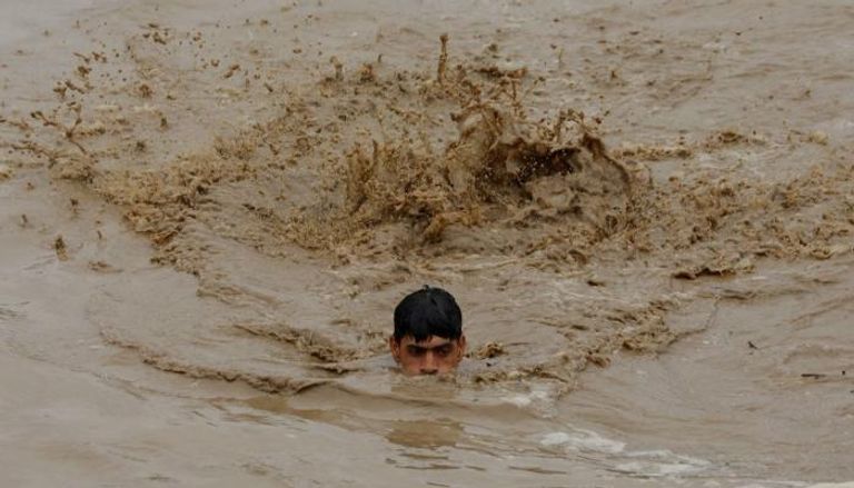 الأمطار  تغطي جسد شخص في باكستان