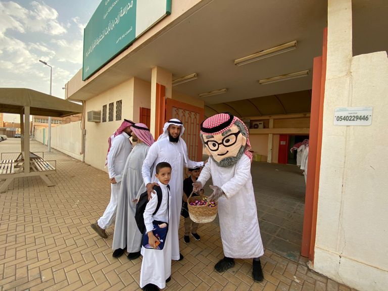 أب يصطحب نجله إلى المدرسة في أول أيام الدراسة