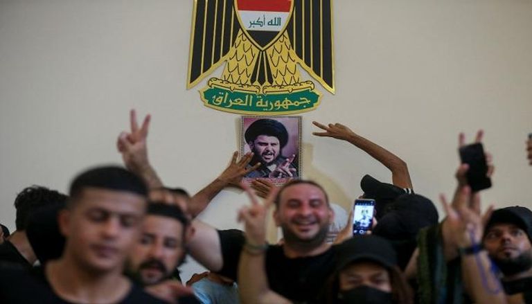 متظاهرون يرفعون صورة لمقتدى الصدر داخل القصر الحكومي في بغداد - رويترز