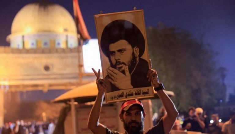 أحد أنصار الصدر يرفع صورته في بغداد