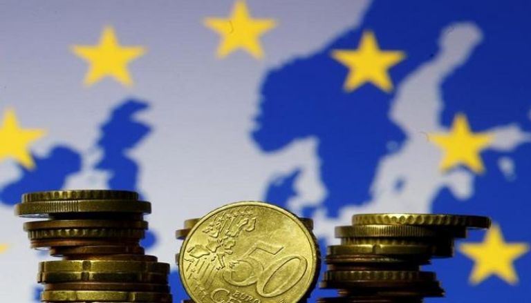عملات اليورو المعدنية أمام علم وخريطة الاتحاد الأوروبي - رويترز