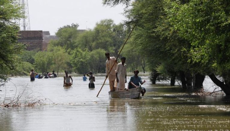 باكستانيون يتنقلون في قارب بعد فيضانات مدمرة
