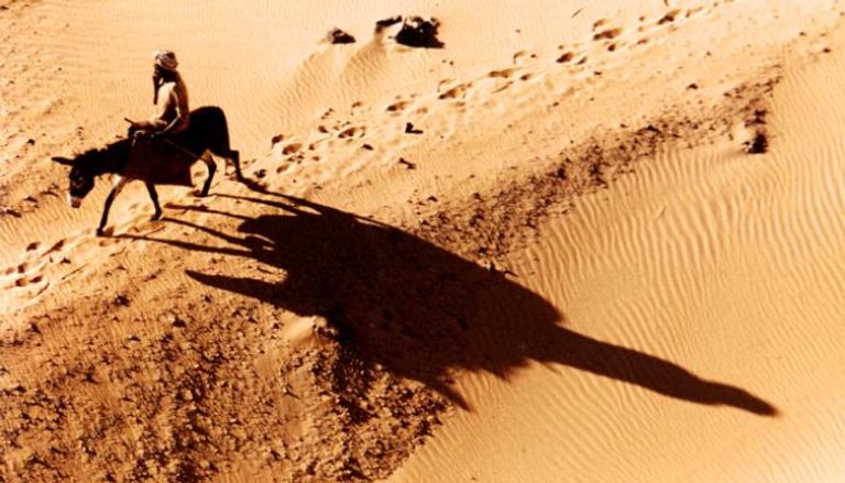 رجل يعبر الصحراء في السودان على ظهر حمار- أرشيفية