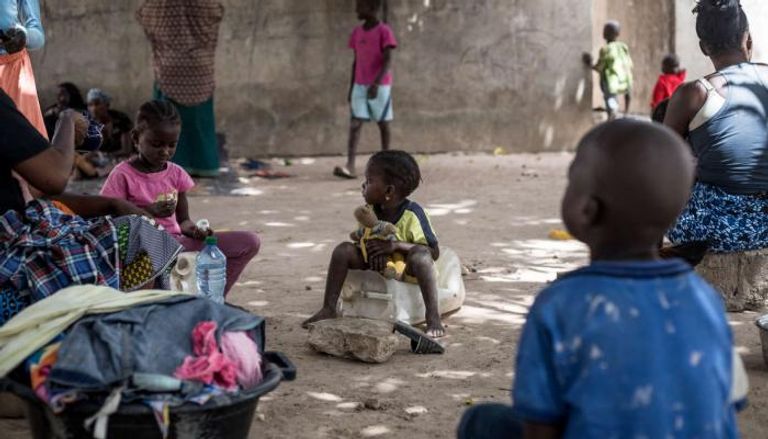 أطفال يجلسون مع أمهاتهم في جامبيا - أرشيفية