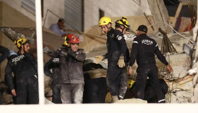 رجال الإنقاذ يباشرون عملهم فوق المبنى المنهار