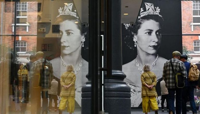 صورة لملكة بريطانيا إليزابيث معلقة في سوق سبيتالفيلدز في شرق لندن