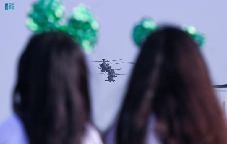 طفل سعودي يلتقط طائرات سعودية تحمل علم المملكة- واس