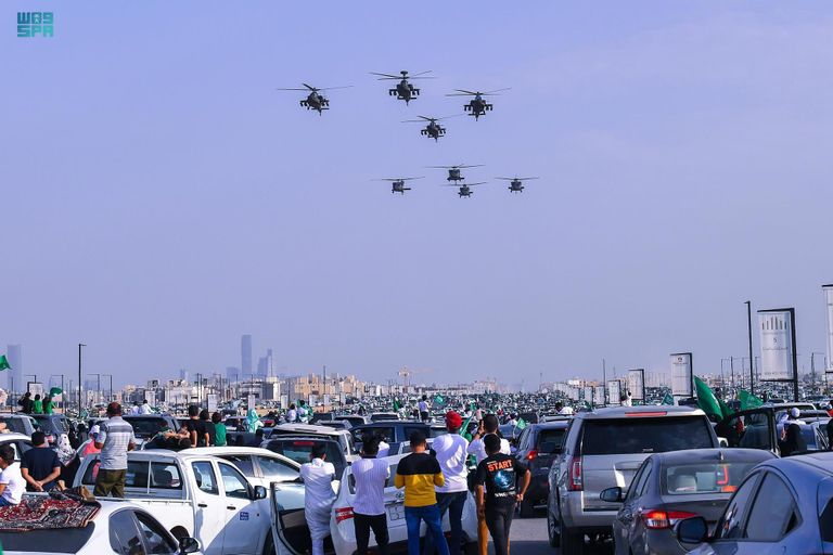 طفل سعودي يلتقط طائرات سعودية تحمل علم المملكة- واس