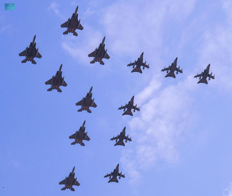 طفل سعودي يلتقط طائرات سعودية تحمل علم المملكة- واس