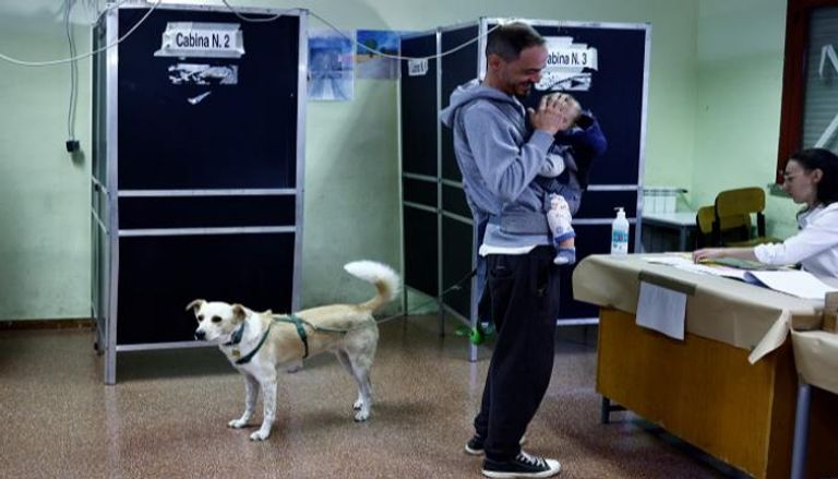 كلب يرافق صاحبه داخل اللجنة الانتخابية بإيطاليا- رويترز