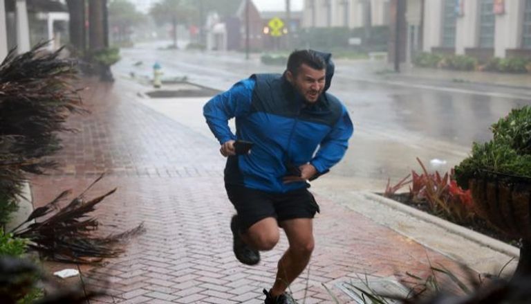 أمريكي يركض في أحد شوارع فلوريدا هربا من 