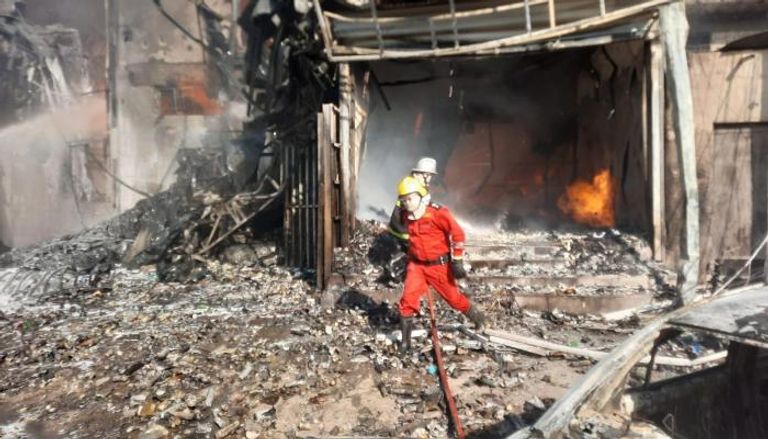 عناصر أطفاء خلال محاولتهم إخماد نيران حادثة حريق ببغداد