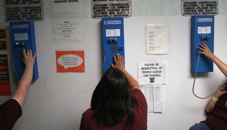 مساجين يجرون مكالمات في مركز يورك لإعادة الإدماج المجتمعي - موقع npr