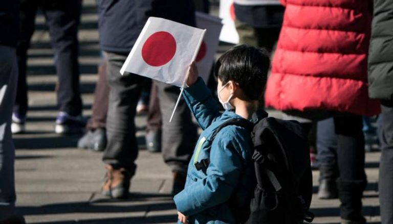 طفل يحمل العلم الياباني