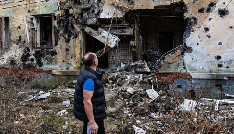 مواطن أوكراني يقف أمام منزل دمره القصف الروسي - أ.ف.ب