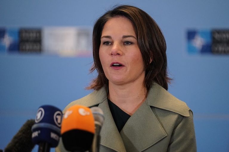 وزيرة الخارجية الألمانية أنالينا بيربوك مواطن أوكراني يقف أمام منزل دمره القصف الروسي - أ.ف.ب