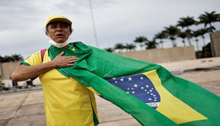 مؤيدة للرئيس البرازيلي السابق جاير بولسونارو تحمل العلم البرازيلي