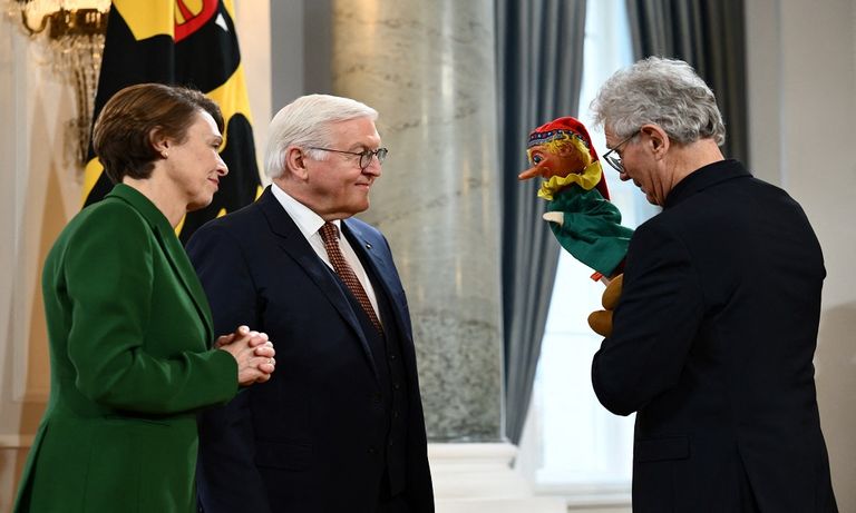 الرئيس الألماني يقف مبتسما أمام إحدى الدمى - رويترز