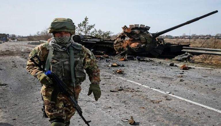 جندي يمر بجانب دبابة محطمة في أوكرانيا- أرشيفية