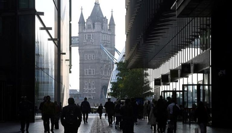 عمال يسيرون باتجاه تاور بريدج في لندن - رويترز