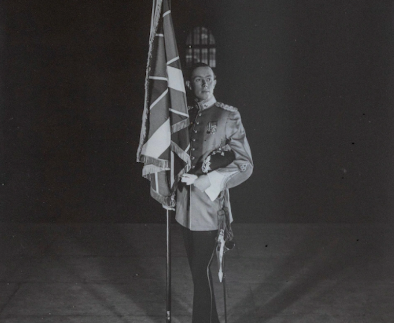 جون والد فرانسيس خلال حفل تتويج الملكة اليزابيث فرانسيس ديموك وخلفه صورة مرسومة لدور الفارس الذي تلعبه عائلته