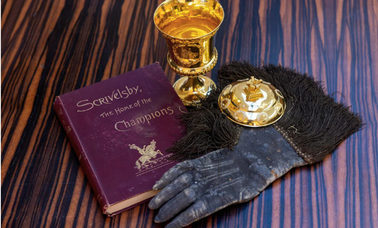 قفاز تستخدمه الأسرة فى المراسم فرانسيس ديموك وخلفه صورة مرسومة لدور الفارس الذي تلعبه عائلته