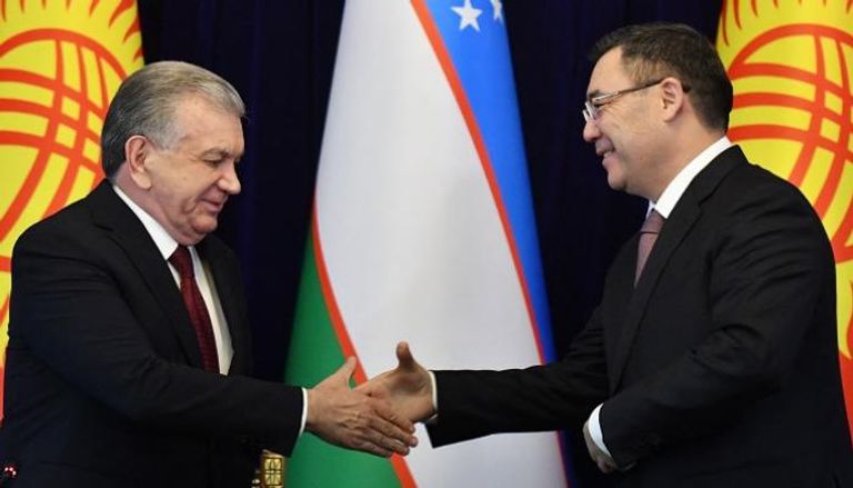 الرئيس القرغيزي صدير جاباروف (يمين) والرئيس الأوزبكي شوكت ميرزيوييف يتصافحان 